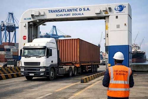 Camion porte-conteneur sous le portique de scanner